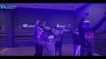 Grupo de participantes disfrutando de una experiencia de realidad virtual en una sala de eventos con iluminación azul