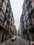 Vista vertical de la Calle Dos de Mayo en Bilbao, flanqueada por edificios residenciales con balcones acristalados