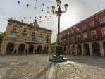 Plaza Mayor de Gijón con el Ayuntamiento y farola central, adornada con banderines festivos