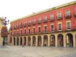 Detalle de la fachada roja y los soportales de la Plaza Mayor de Gijón