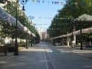 Perspectiva del paseo central arbolado con estructuras y banderines para eventos