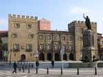 Vista frontal del Palacio de Revillagigedo y la estatua de Pelayo en la Plaza del Marqués