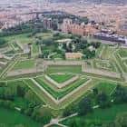 Vista aérea oblicua de la Ciudadela de Pamplona y sus baluartes verdes, con la ciudad al fondo