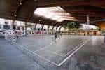 Cancha deportiva cubierta multiusos con techo de madera y luz natural