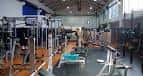 Vista general del interior del gimnasio con máquinas de pesas y equipamiento de entrenamiento