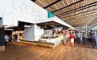 Interior moderno del mercado con puestos de gastronomía y techo de madera laminada