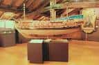 Interior del museo con exposición de embarcación tradicional y estructura de madera