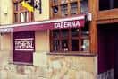 Vista cercana de la fachada de Parral Taberna con el toldo granate