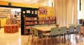 Sala de lectura o reunión con mesas y sillas en un ambiente luminoso y colorido