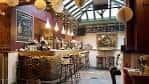 Interior del bar y zona de eventos con techo acristalado y decoración festiva
