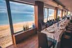 Salón interior para eventos con grandes ventanales y vistas panorámicas a la playa