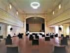 Interior del Aula San Pablo con vista hacia el escenario y la pantalla de proyección