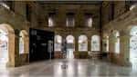 Sala de exposiciones interior con arquitectura tradicional de piedra