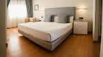 Habitación doble moderna con cama amplia y suelos de madera