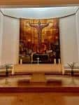 Primer plano del altar y el mural del presbiterio