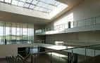 Interior del vestíbulo con diseño contemporáneo, pasarelas de cristal y entrada de luz natural cenital