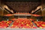 Interior del auditorio principal con filas de butacas en tonos rojos y diseño moderno