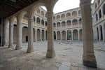 Patio interior porticado con arquerías de piedra y tres niveles de galerías