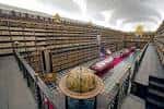 Vista de la histórica biblioteca con estanterías de madera tallada y techos abovedados