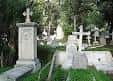 Vista de lápidas y cruces históricas entre la vegetación del cementerio