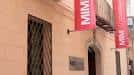 Fachada exterior del Museo Interactivo de la Música con estandartes rojos en la entrada
