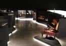 Sala de exposición interior con instrumentos musicales iluminados en vitrinas