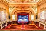 Vista del escenario y el proscenio desde el anfiteatro con detalles ornamentales en techo y paredes