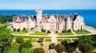 Vista panorámica del palacio rodeado de jardines con el mar Cantábrico al fondo