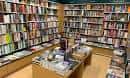 Vista del interior de la librería con estanterías de madera y mesas de exposición
