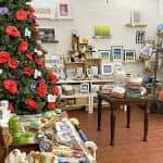 Interior de la galería con exhibición de cuadros y decoración navideña