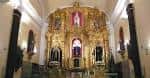 Vista interior de la capilla con el altar mayor y bancos para los fieles