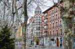 Vista del paseo peatonal de la Acera de Recoletos con edificios históricos y arbolado