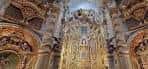 Interior de la iglesia mostrando el retablo mayor y la profusa decoración barroca