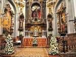 Detalle del altar mayor con ornamentación barroca y arreglos florales