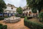 Patio de la fuente con arquerías y vegetación cuidada