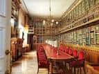 Salón histórico con biblioteca y mesa para reuniones