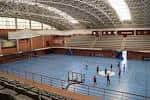 Interior del pabellón polideportivo de la Universidad de Málaga con canchas y gradas
