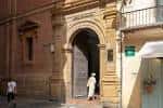 Entrada principal al edificio histórico con arco de medio punto en piedra