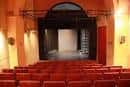 Escenario del teatro con iluminación frontal visto desde la zona de asientos