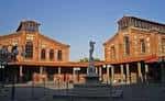 Vista exterior de los pabellones históricos de ladrillo y la plaza central con escultura