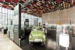Interior del museo con exhibición de coches clásicos y techos técnicos