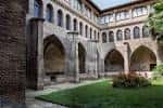 Vista del claustro mudéjar con arcos apuntados y zona ajardinada central