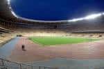 Vista nocturna del campo de fútbol y la pista de atletismo desde la grada