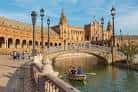 Puente con azulejos sobre el canal de la Plaza de España con barcas de recreo