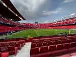 Vista interior del estadio mostrando el terreno de juego y las gradas en color rojo