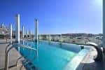Terraza con piscina y vistas panorámicas de la ciudad en la azotea de un hotel