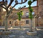 Fachada de piedra del Museo Casa Natal de Jovellanos vista desde la plaza arbolada