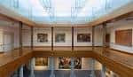 Galería interior del museo con pinturas expuestas y techo acristalado