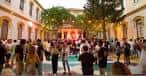 Ambiente de un evento cultural en el patio interior con iluminación decorativa