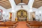 Altar mayor y bancos de madera en el interior de la parroquia